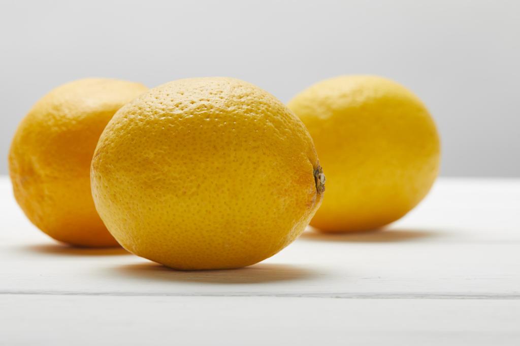 Спелые органические лимоны на белом деревянном столе изолированы на сером
 - Фото, изображение
