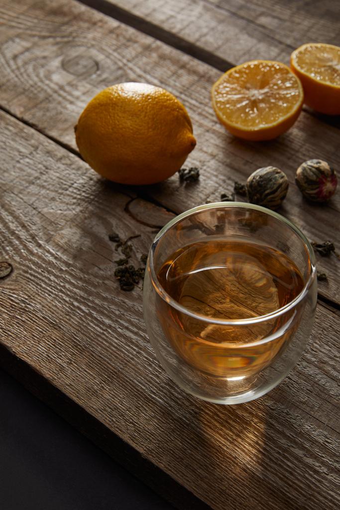 vidro de chá tradicional chinês florescendo e limões na mesa de madeira
  - Foto, Imagem