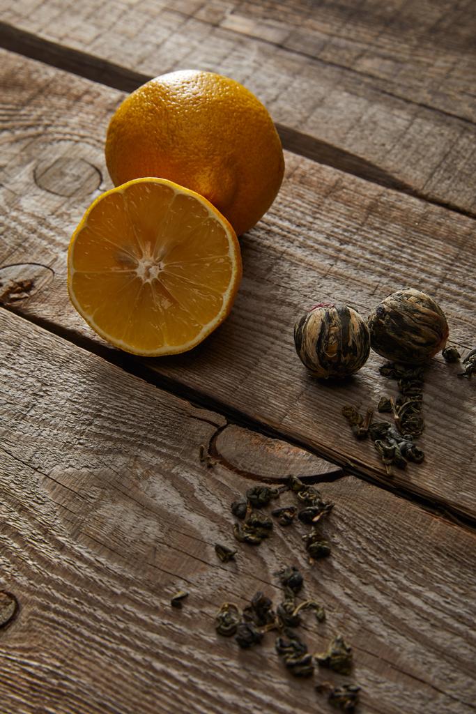 citrons frais et boules de thé en fleurs sur table rustique en bois
 - Photo, image