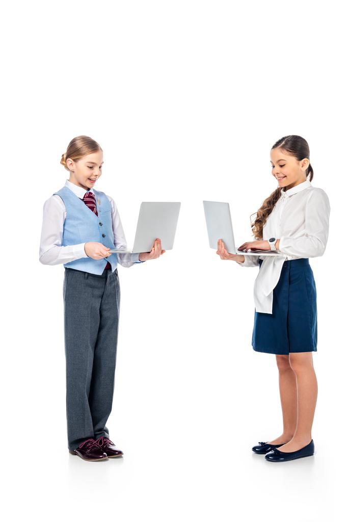 sorridente studentesse in abbigliamento formale utilizzando i computer portatili su bianco
 - Foto, immagini
