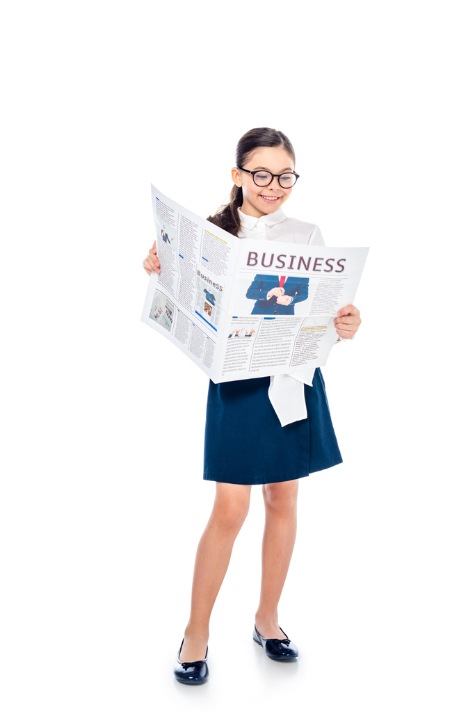 adorable schoolgirl in formal wear and glasses reading business newspaper On White - Photo, Image