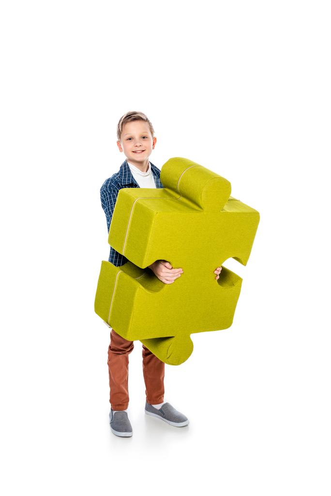 happy boy with jigsaw puzzle piece looking at camera on white - Photo, Image