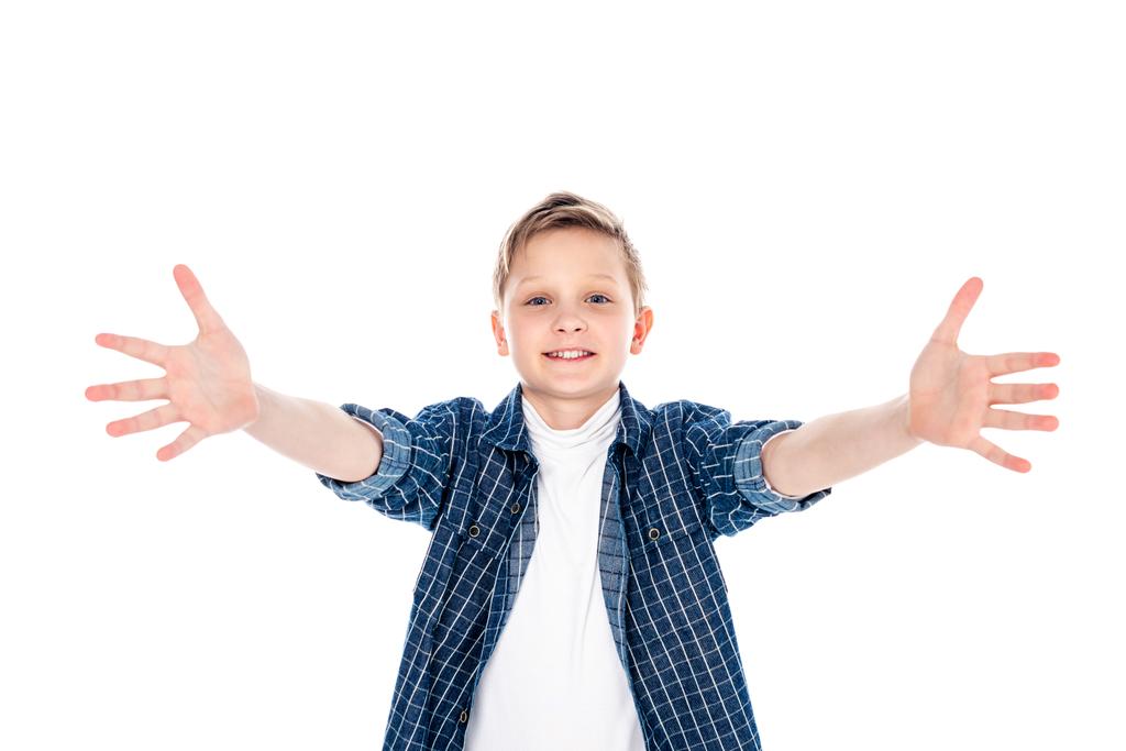 adorable niño sonriente en ropa casual con las manos extendidas aisladas en blanco
 - Foto, Imagen