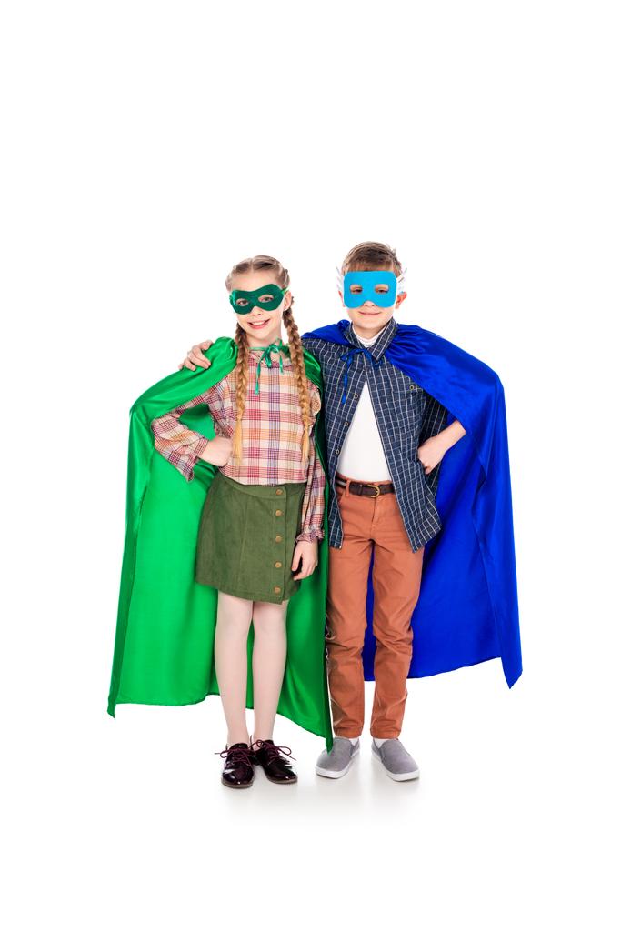 Kinder in Superheldenkostümen und Masken mit Händen auf Hüften auf weiß - Foto, Bild