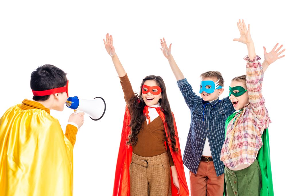 onnellinen lapset supersankari puvut nostaa kätensä, kun poika huutaa suukappaleen eristetty valkoinen
 - Valokuva, kuva