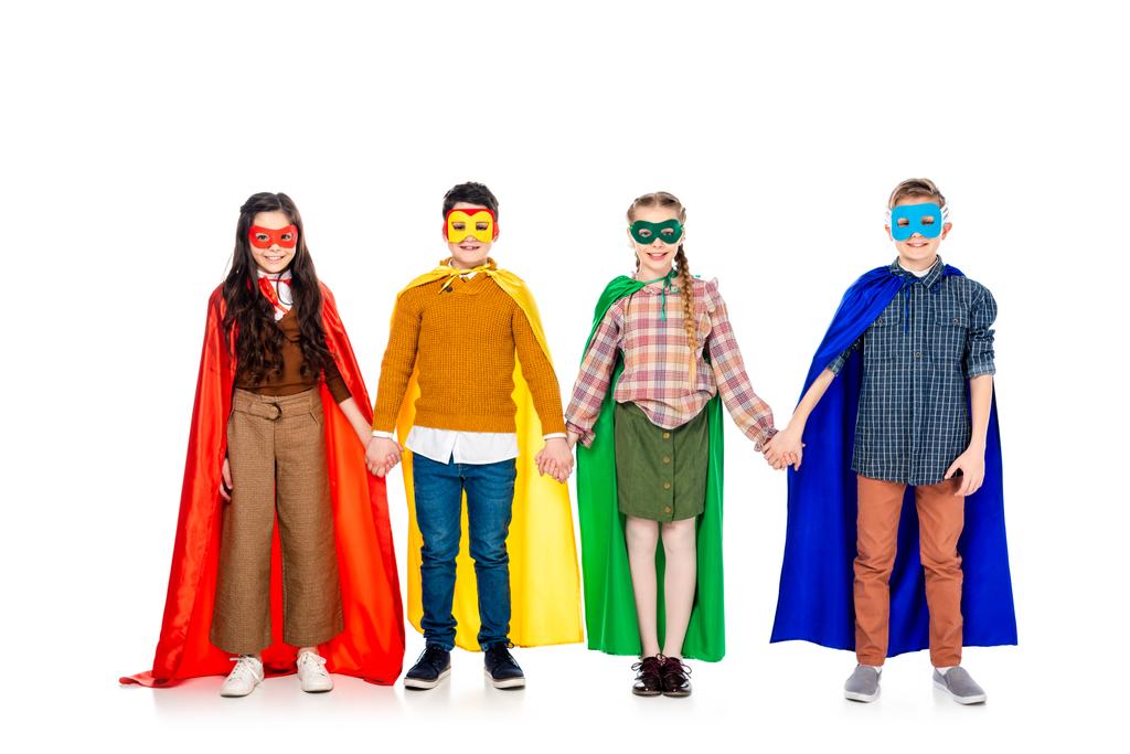 bambini felici in costumi da supereroe e maschere che si tengono per mano su bianco
 - Foto, immagini