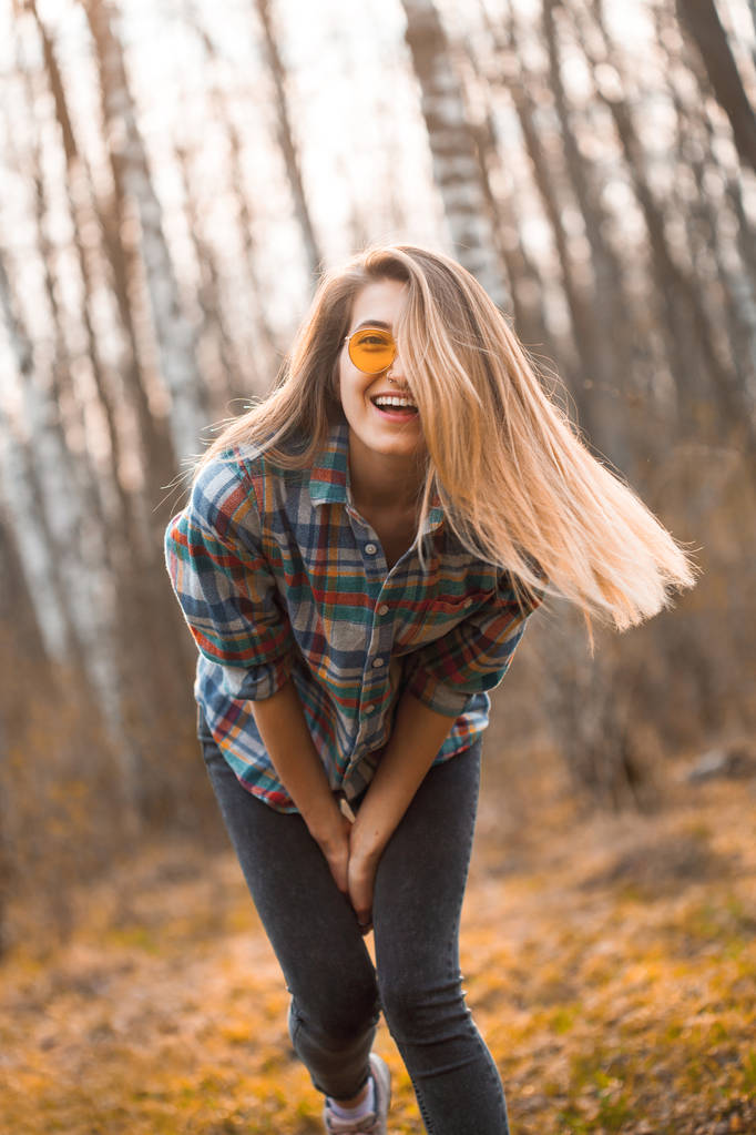 Νεαρή γυναίκα γελάει και διασκεδάζει στο δάσος. - Φωτογραφία, εικόνα