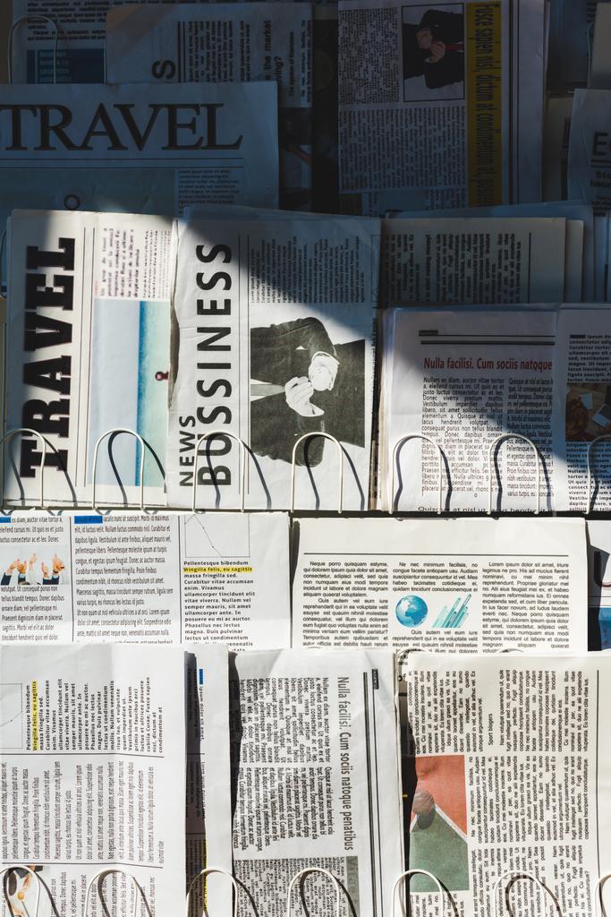 different print business and travel newspapers on stand in sunlight - Photo, Image