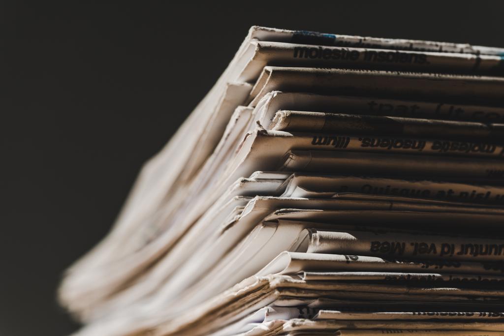 Различные печатные газеты в куче изолированы на черном
 - Фото, изображение