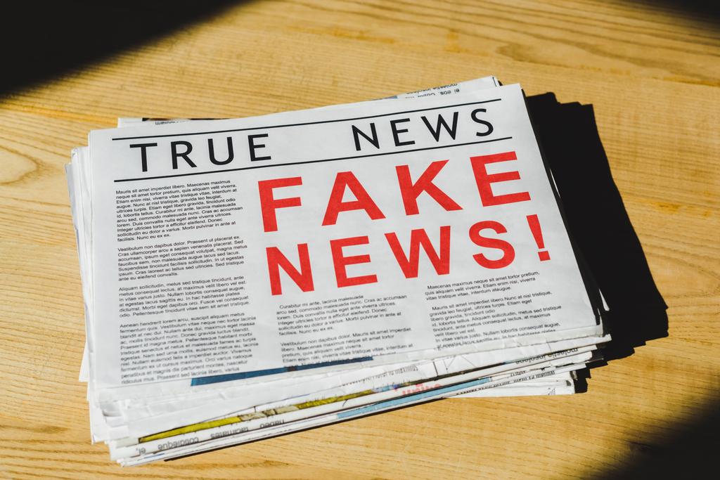 pila de periódicos con noticias falsas y verdaderas en la mesa de madera
 - Foto, Imagen