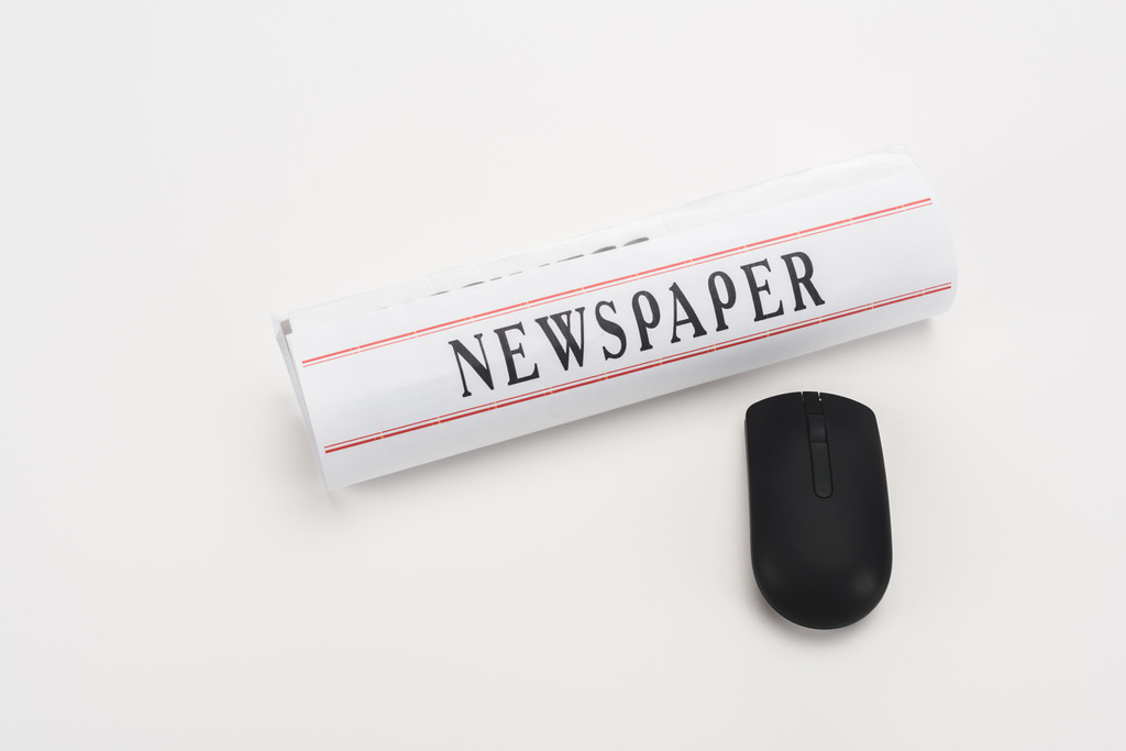 periódico impreso laminado cerca del ratón negro inalámbrico de la computadora sobre fondo blanco
 - Foto, Imagen