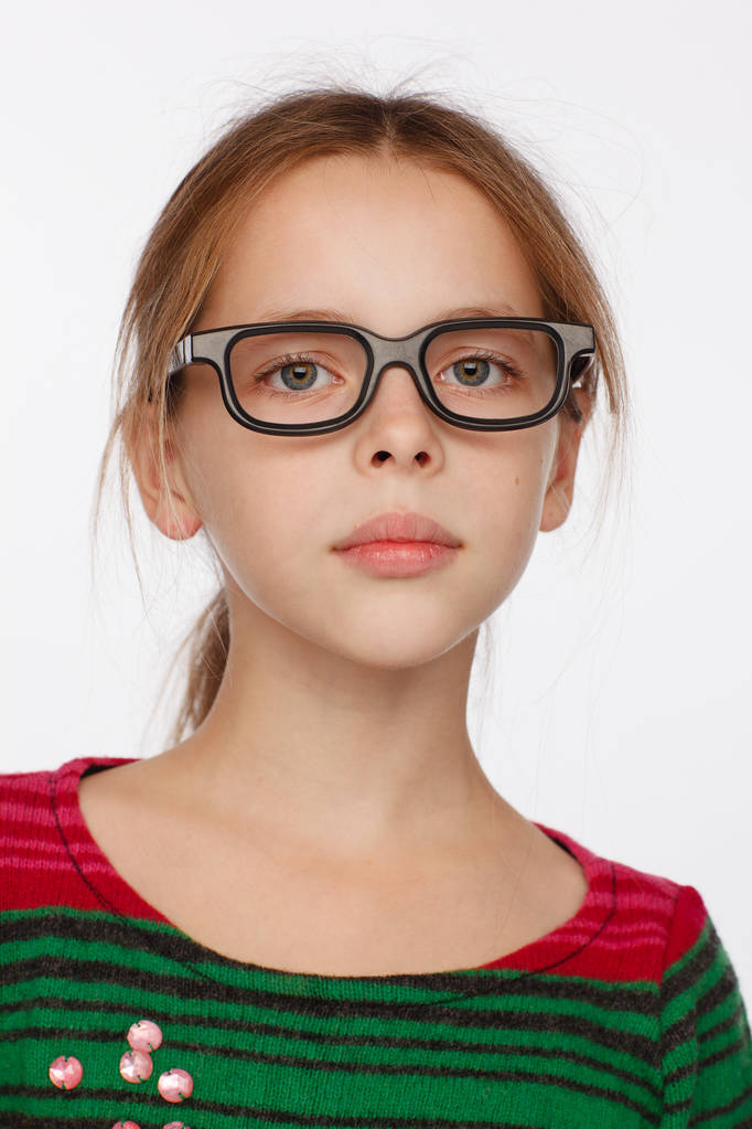 Portret van 8-jarig meisje in een bril en een trui in een karmozijnrode en groene strepen. Studio fotosessie - Foto, afbeelding