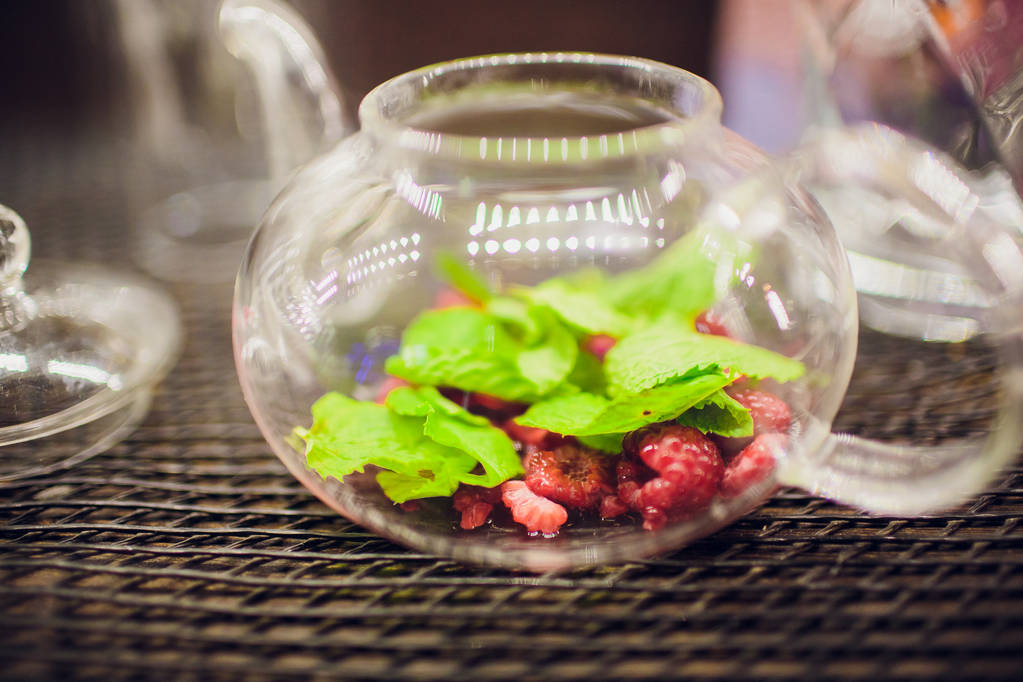 Früchtetee mit Waldbeeren in Glasschale, auf Tisch, auf hellem Hintergrund. - Foto, Bild