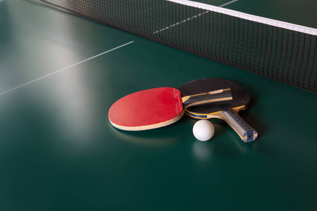 Dva pingpongové rakety a míč na zeleném stole. ping-pongová síť - Fotografie, Obrázek