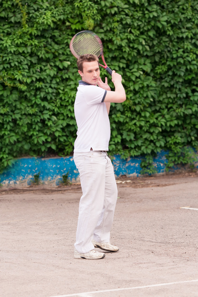 ekspresyjny młody człowiek, grać w tenisa - Zdjęcie, obraz