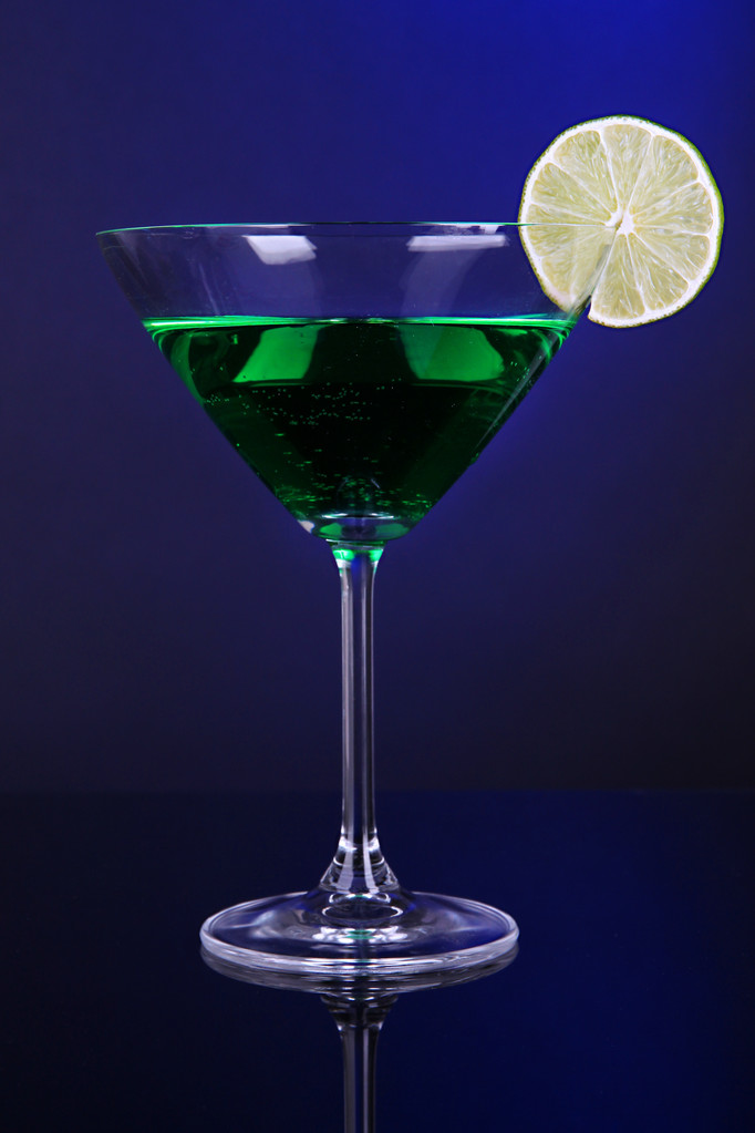 grüner Cocktail in Martini-Glas auf dunkelblauem Hintergrund - Foto, Bild