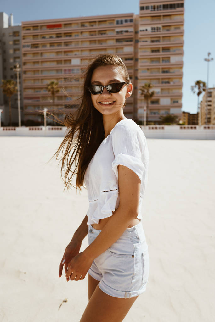 Chica bronceada de moda posando en la playa, mirando a la cámara. Playas españolas
 - Foto, imagen