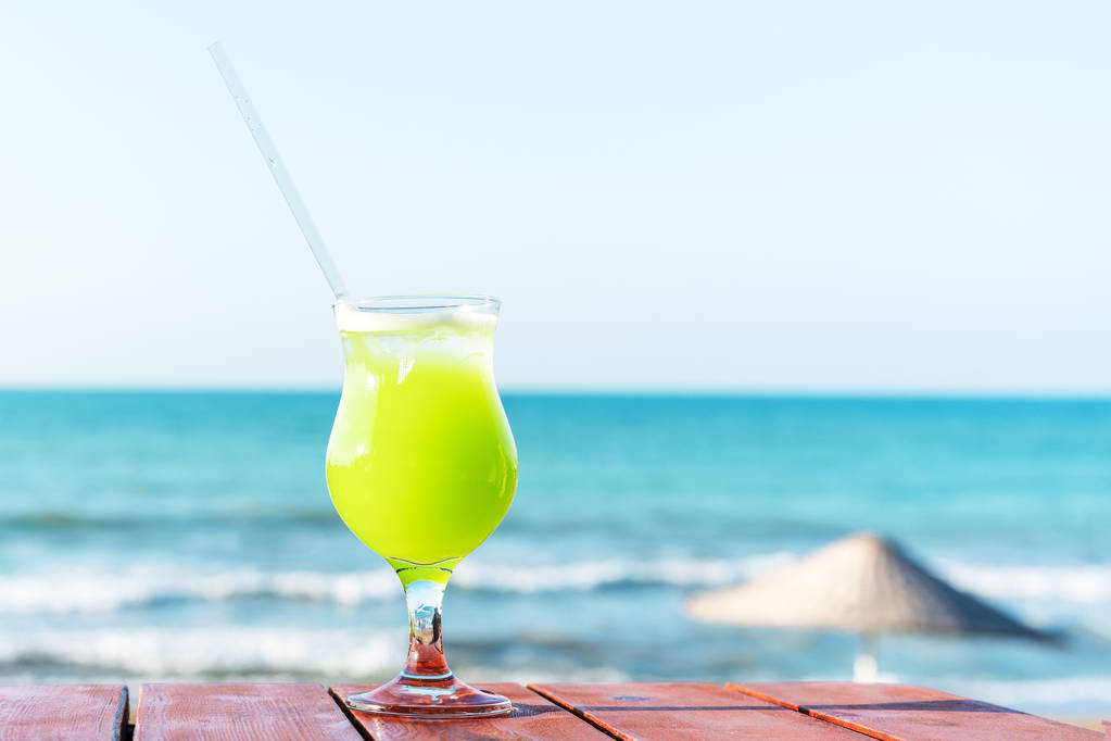 sahilde taze yeşil tropikal meyve suyu bir bardak, masada, denize karşı - Fotoğraf, Görsel