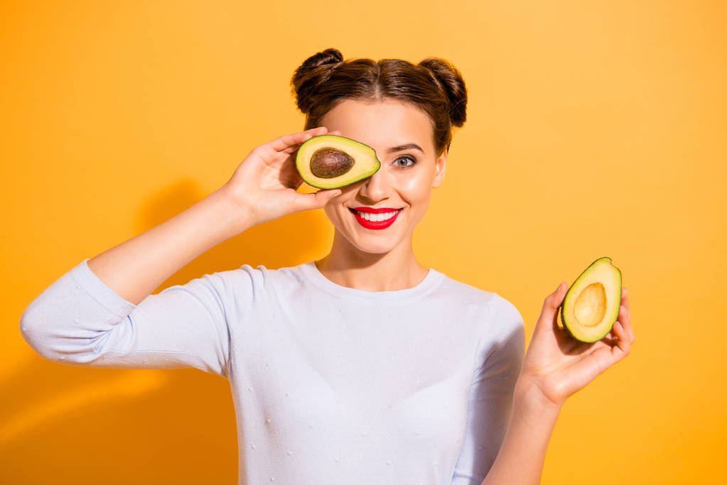 Close up photo beautiful she her lady pretty hairdo hold slices avocado hide eye used amazing salon mask oil extract procedure wearing casual white pullover clothes isolated yellow background - Photo, Image