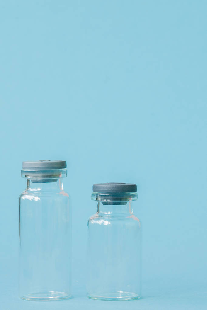 Medikamentenflasche auf blauem Hintergrund mit Kopierraum. Antibiotika oder Impfstoffe. Innovationen im Gesundheitswesen und in der Pharmazie - Foto, Bild