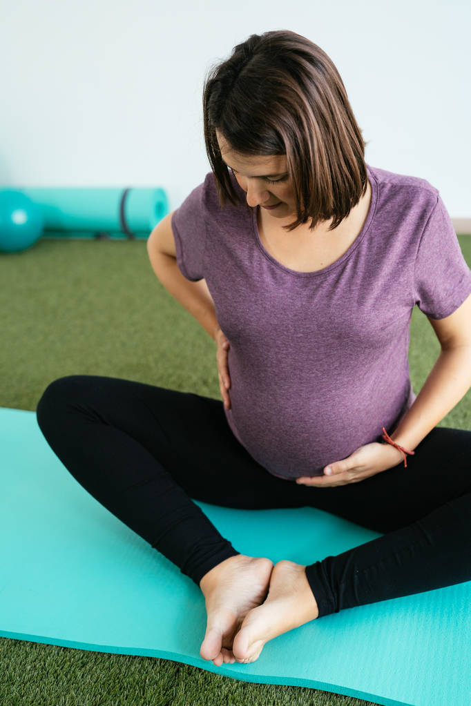 Беременная женщина делает фитнес-мяч и пилатес упражнения с coac
 - Фото, изображение