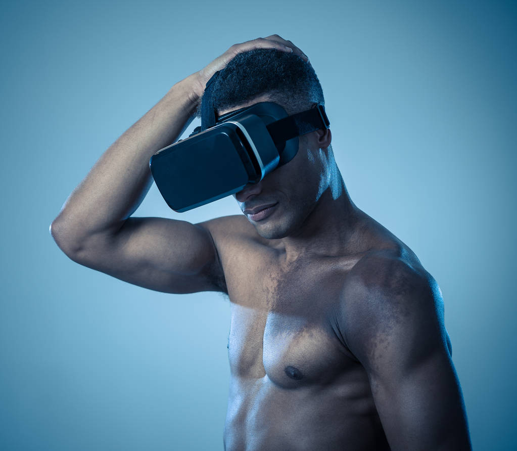 Attractive powerful african american man using augmented or VR goggles exploring new 3d world. Advertising of the power of virtual reality and augmented reality technology. 360 degree VR experiences. - Photo, Image