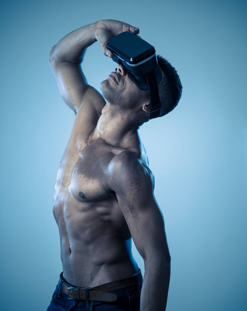 Atractivo hombre afroamericano poderoso utilizando gafas aumentadas o VR explorar nuevo mundo 3d. Publicidad del poder de la realidad virtual y la tecnología de realidad aumentada. Experiencias VR de 360 grados
. - Foto, imagen