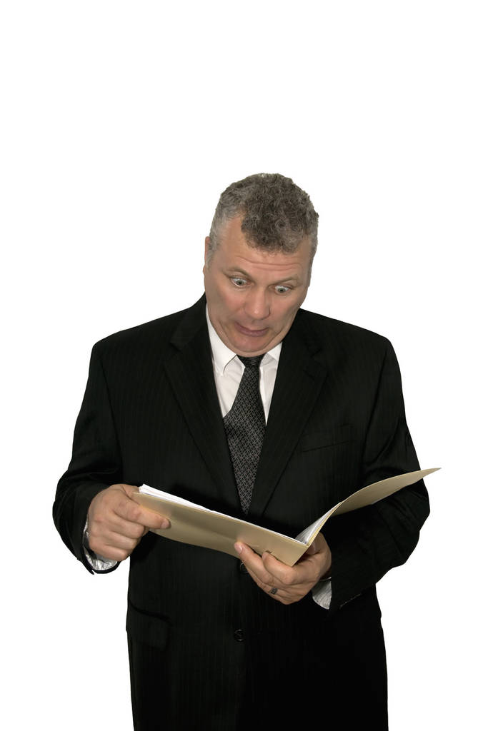 Бізнесмен середнього віку, який виглядає шокованим під час читання з теки
. - Фото, зображення