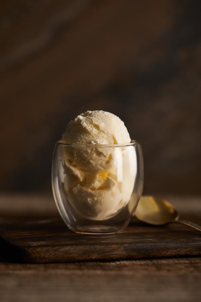 смачне морозиво в склянці з ложкою на дерев'яному столі
 - Фото, зображення