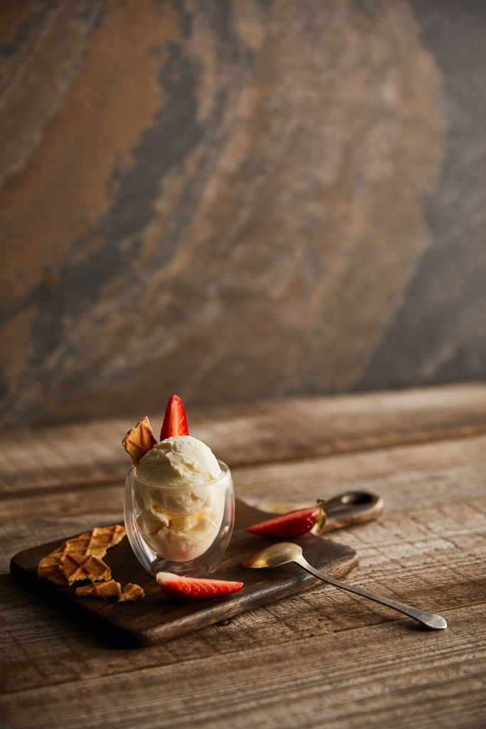 delicioso sorvete em vidro com morangos e pedaços de waffle na tábua de corte na mesa com espaço de cópia
 - Foto, Imagem