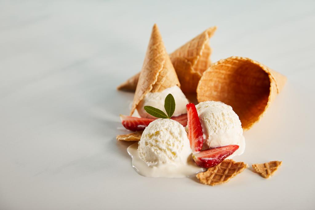 waffle cones and delicious melting ice cream with strawberries on grey table with copy space - Photo, Image
