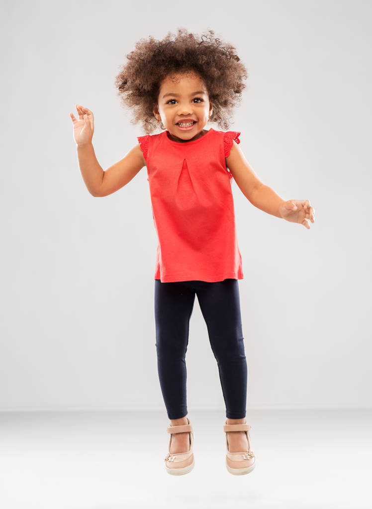 boldog kis afro-amerikai lány jumping - Fotó, kép