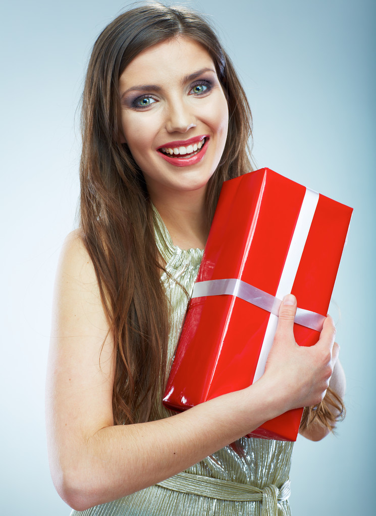 赤いギフト ボックスを保持しているイブニング ドレスを着た女性の笑みを浮かべてください。. - 写真・画像