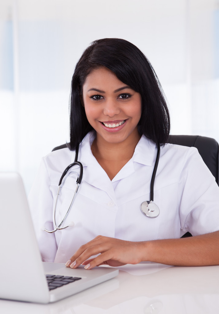 Szczęśliwa kobieta lekarz za pomocą laptopa - Zdjęcie, obraz