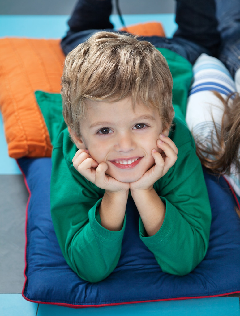 chlapec s hlavou v ruce ležící na polštářích v mateřské školce - Fotografie, Obrázek