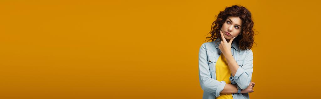 πανοραμική βολή της σκεπτικής γυναίκας σκέψης ενώ στέκεται στο πορτοκαλί  - Φωτογραφία, εικόνα