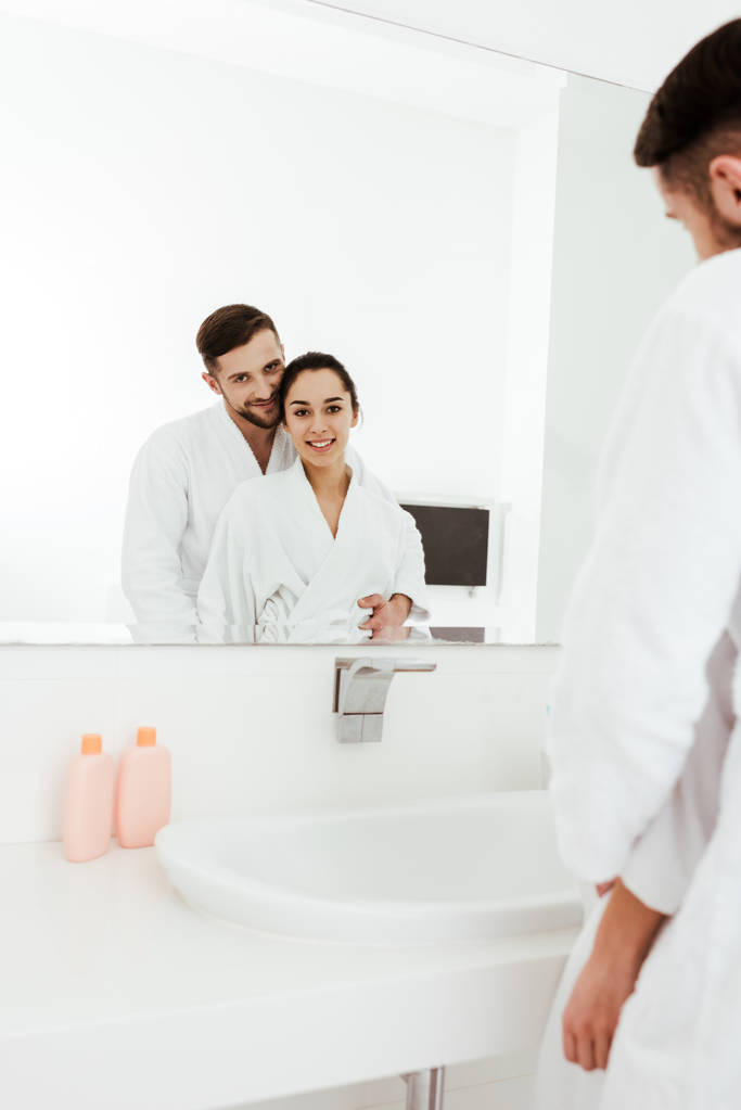 вибірковий фокус бородатого чоловіка дивиться на дзеркало з щасливою брюнеткою жінкою
  - Фото, зображення