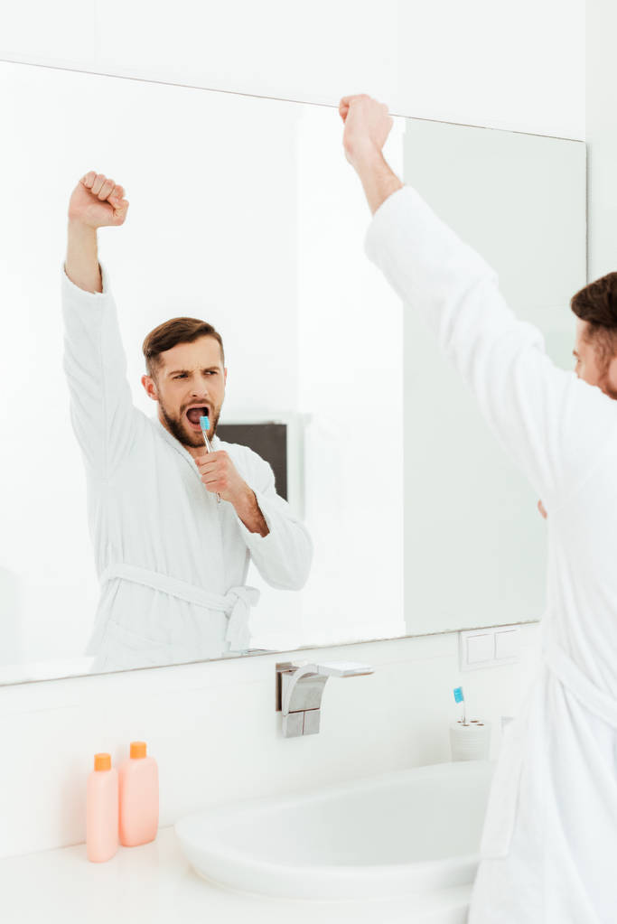 вибірковий фокус красивого бородатого чоловіка, який тримає зубну щітку і жестикулює у ванній
  - Фото, зображення