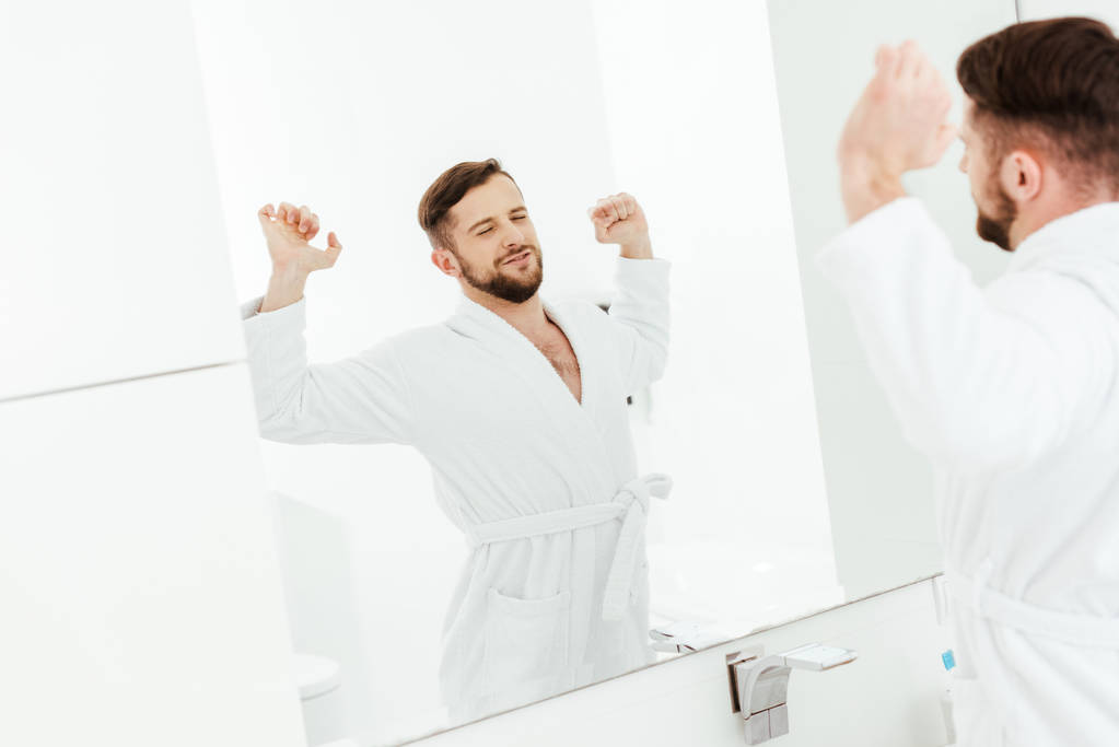 селективный фокус счастливого бородатого мужчины растягивается после пробуждения в ванной комнате
  - Фото, изображение