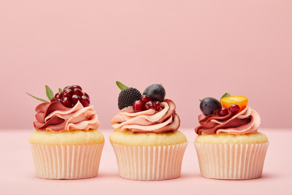 cupcakes doces com frutas e bagas na superfície rosa
 - Foto, Imagem
