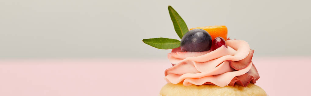Colpo panoramico di cupcake con uva, kumquat e granato su grigio e rosa
 - Foto, immagini