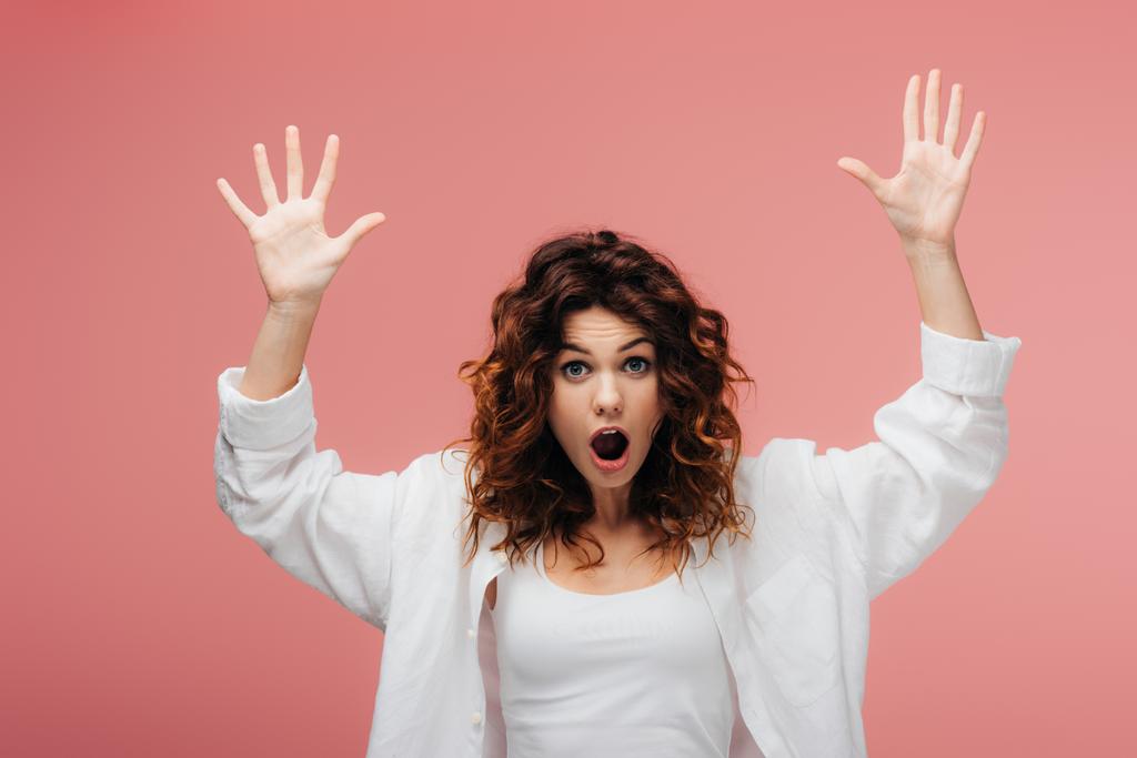 shocked curly woman with red hair gesturing on pink - Photo, Image