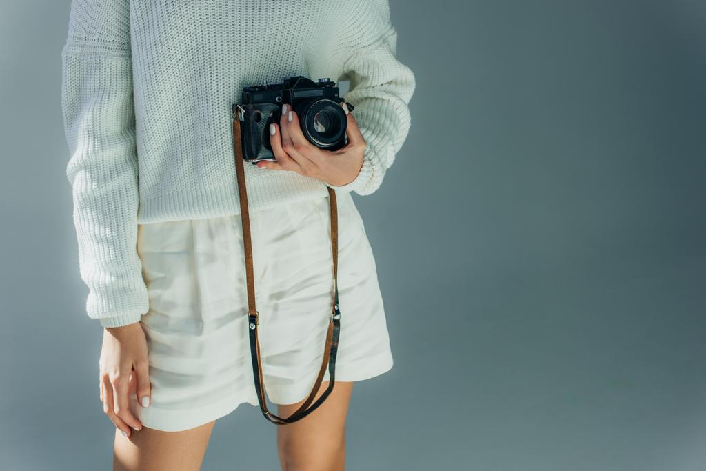 обрізаний вид молодої жінки, що тримає цифрову камеру на сірому
  - Фото, зображення