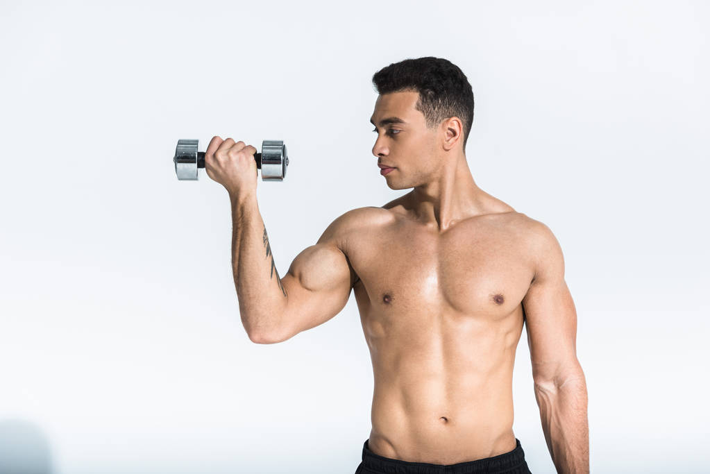 handsome mixed race man with muscular torso holding dumbbells on white - Photo, Image