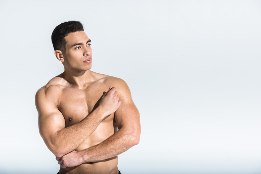 hombre deportivo guapo con el torso muscular mirando hacia otro lado en blanco
 - Foto, Imagen