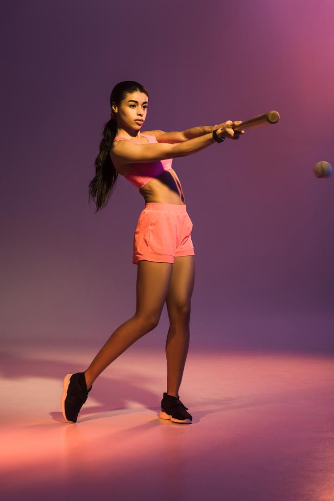 atraente esportivo Africano americano menina jogando beisebol no fundo roxo
 - Foto, Imagem