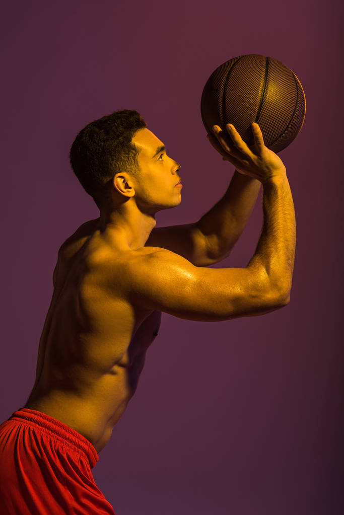 guapo deportivo mestizo raza hombre jugando pelota sobre púrpura fondo
 - Foto, imagen