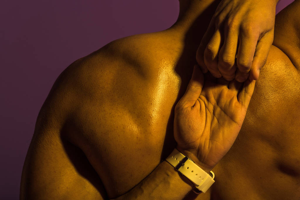 takaisin näkymä urheilullinen mies lihaksikas vartalo venyttely eristetty violetti
 - Valokuva, kuva