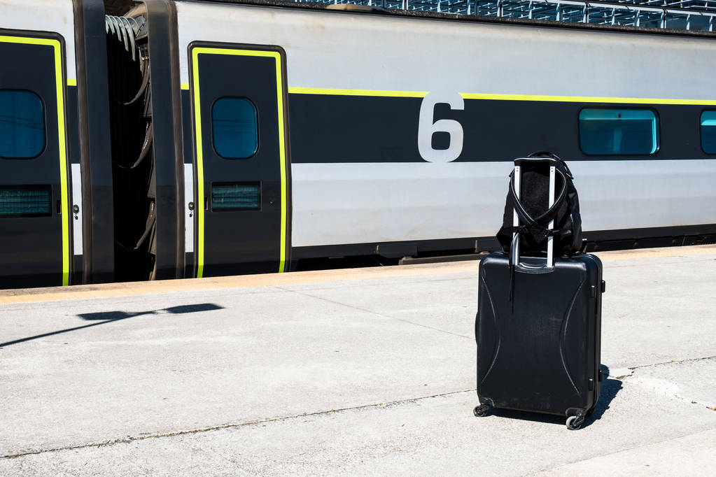 Mochila e mala com rodas na estação de trem. Bagagem enquanto espera pelo comboio. Conceito de viagem
 - Foto, Imagem