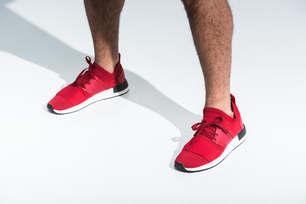 cropped view of sportive man in red sneakers on white background - Photo, Image